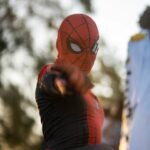 a man in a spider man costume holding a bat